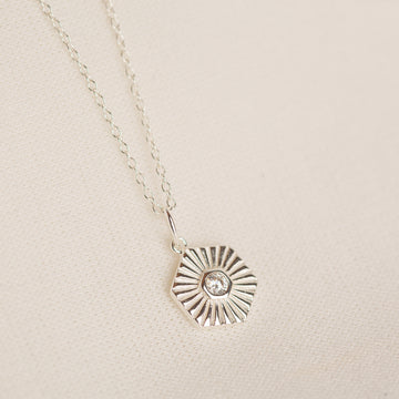 a silver necklace with a diamond in the center