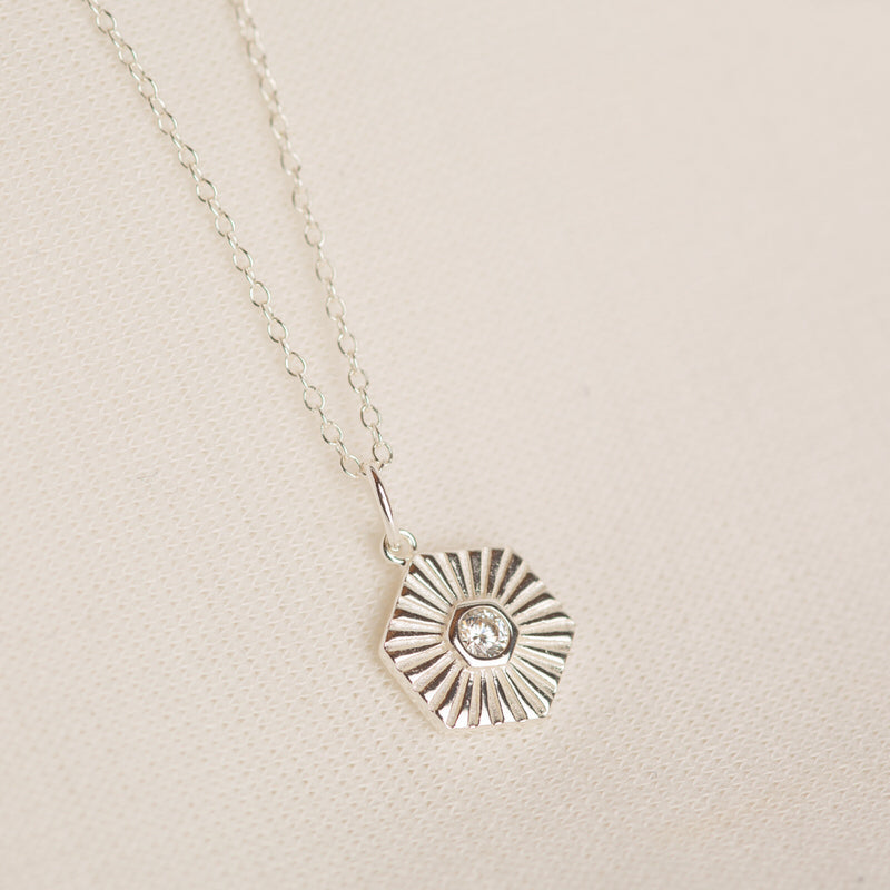 a silver necklace with a diamond in the center