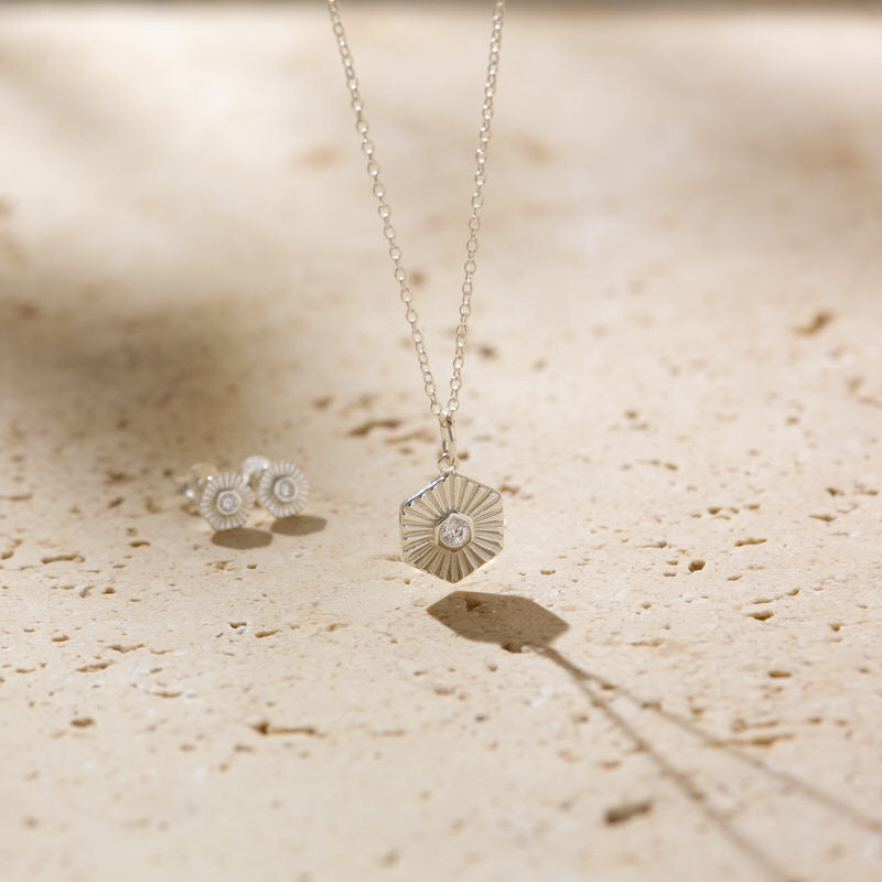 a necklace and earrings sitting on a table