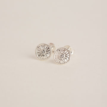 a pair of silver earrings on a white background