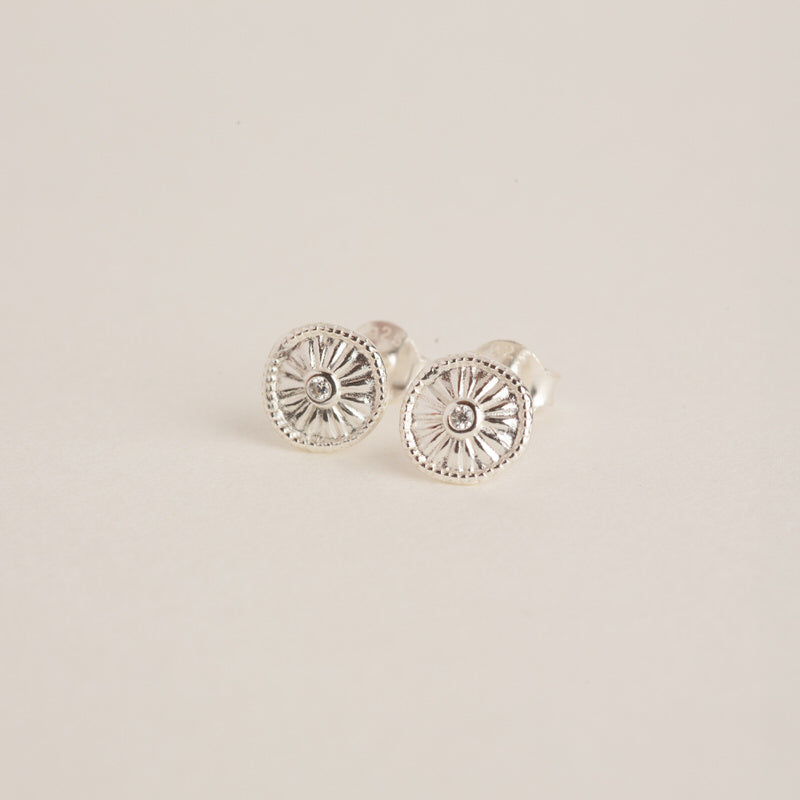 a pair of silver earrings on a white background