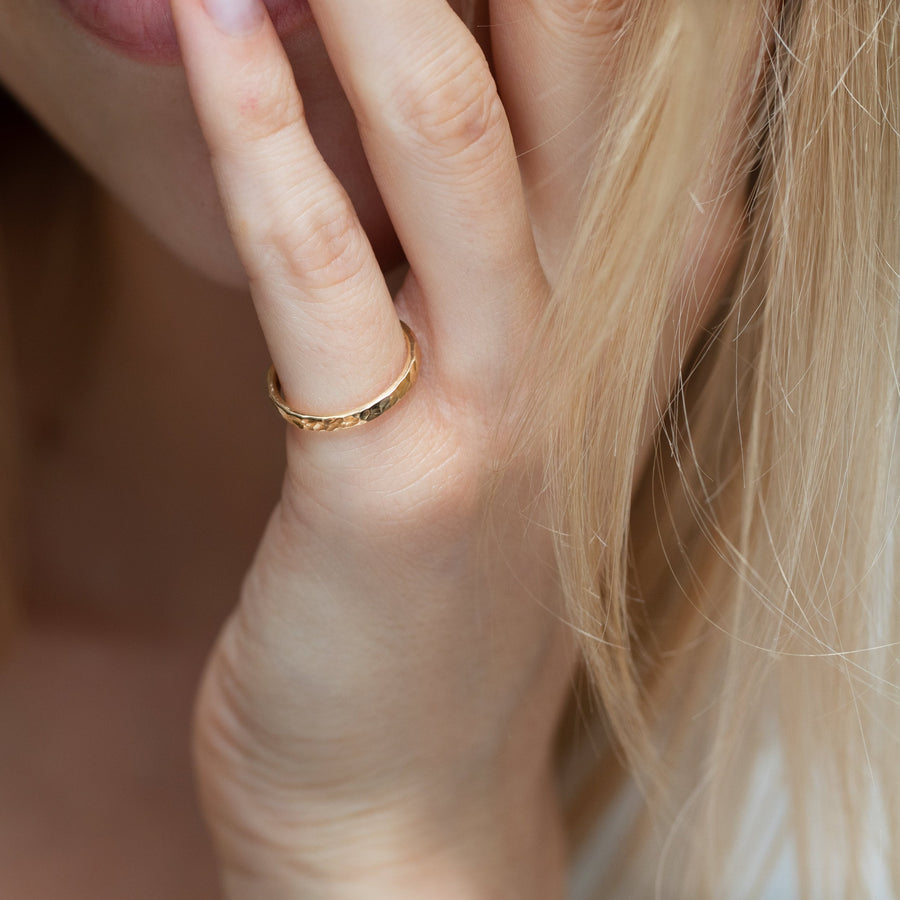 Gold hammered ring on model's finger